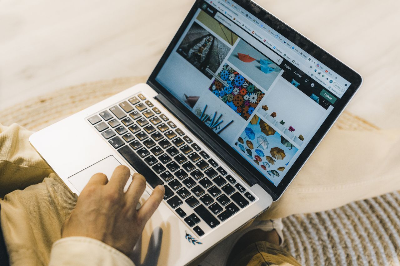 gallery-02 A person using a laptop to browse stock photo websites. Freelancing work in a cozy setting.
